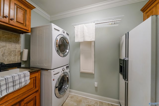 washroom featuring stacked washer and dryer and ornamental molding