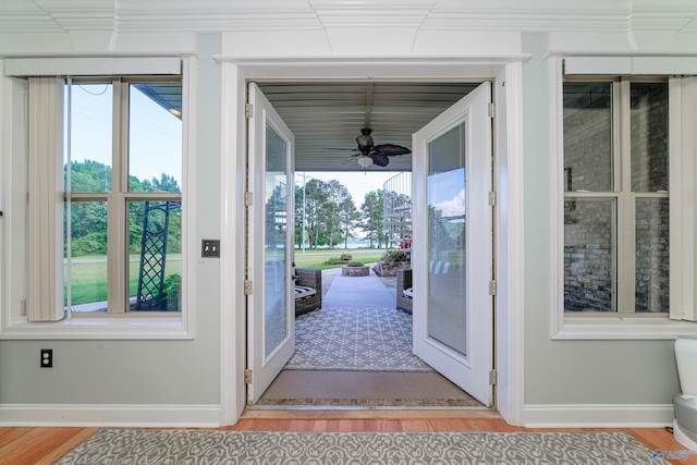 doorway with a healthy amount of sunlight, hardwood / wood-style floors, and ceiling fan