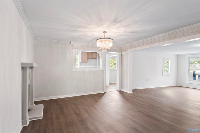 unfurnished living room with ornamental molding, dark hardwood / wood-style floors, and a chandelier