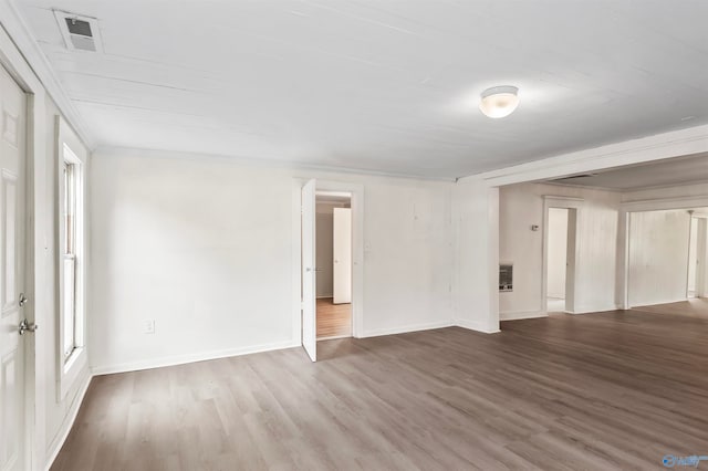 empty room featuring hardwood / wood-style flooring and heating unit