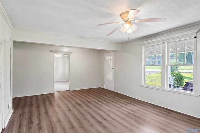 empty room with dark wood-type flooring, crown molding, and a textured ceiling