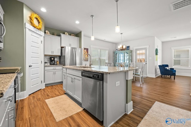 9130 Monteagle Blvd, Owens Cross Roads, AL 35763 - kitchen featuring appliances with stainless steel finishes, a sink, wood finished floors, a kitchen island with sink, and recessed lighting