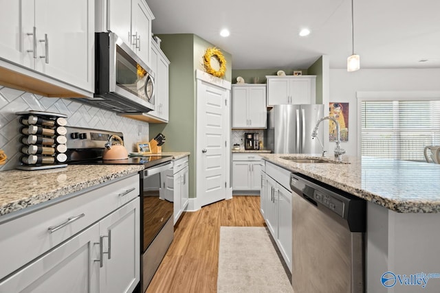 9130 Monteagle Blvd, Owens Cross Roads, AL 35763 - kitchen with appliances with stainless steel finishes, a sink, light wood-style floors, decorative backsplash, and white cabinets
