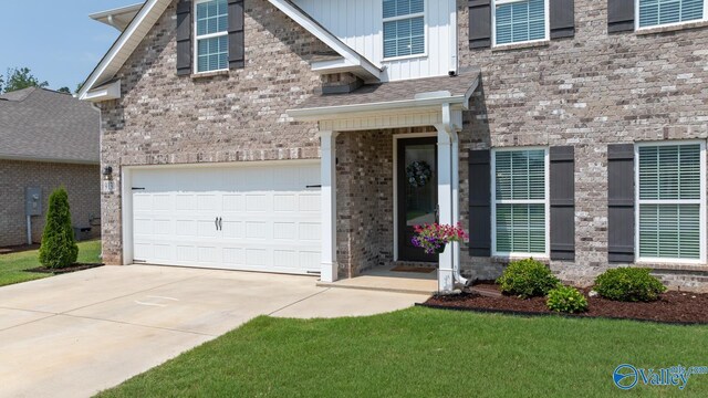 9130 Monteagle Blvd, Owens Cross Roads, AL 35763 - view of front of property featuring driveway, board and batten siding, brick siding, and an attached garage