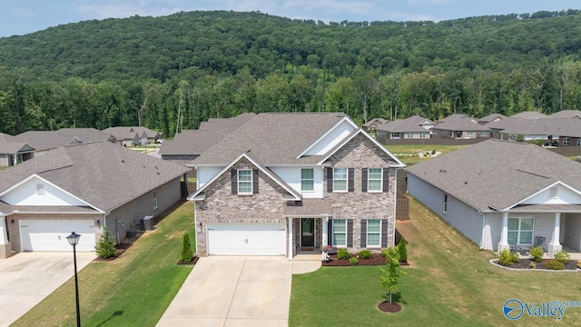 9130 Monteagle Blvd, Owens Cross Roads, AL 35763 - traditional home with concrete driveway, a view of trees, and brick siding