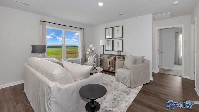 living room with baseboards, wood finished floors, and visible vents