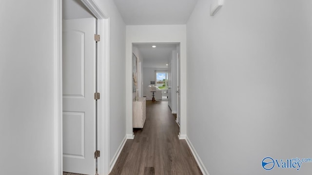 hall featuring baseboards and dark wood-style flooring