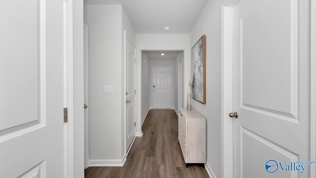 hall featuring baseboards and wood finished floors