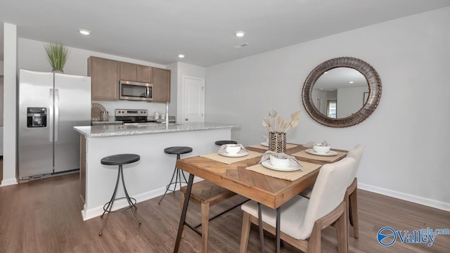 dining room featuring baseboards, visible vents, dark wood-style floors, and recessed lighting