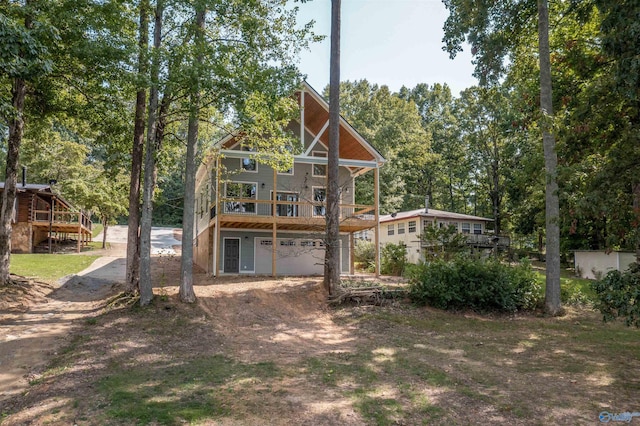 rear view of house with a wooden deck and a garage