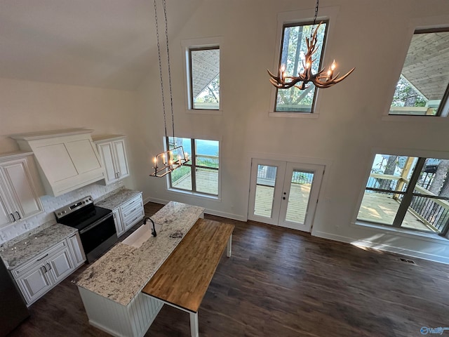 interior space with an inviting chandelier, hanging light fixtures, and stainless steel electric range