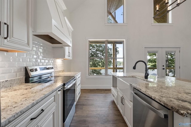 kitchen with stainless steel appliances, custom range hood, and white cabinets