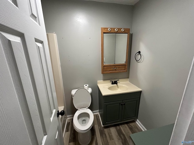3185 Reeves Rd, Hokes Bluff, AL 35903 - half bathroom with wood finished floors, vanity, toilet, and baseboards