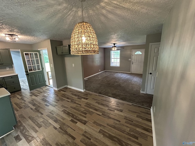 3185 Reeves Rd, Hokes Bluff, AL 35903 - unfurnished dining area with a textured ceiling, dark wood-type flooring, baseboards, and a ceiling fan