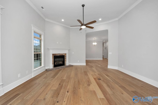 unfurnished living room featuring crown molding, a fireplace, ceiling fan, and light wood-type flooring