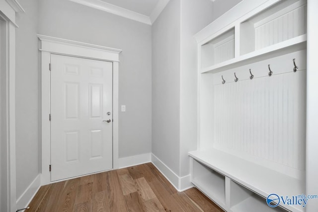 mudroom with wood-type flooring and crown molding