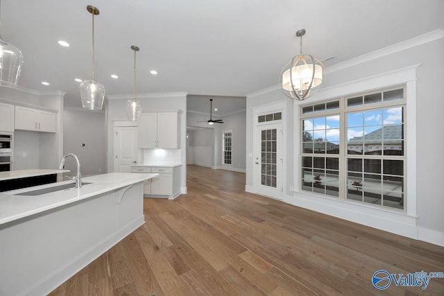 kitchen featuring sink, white cabinetry, tasteful backsplash, ceiling fan, and light stone countertops