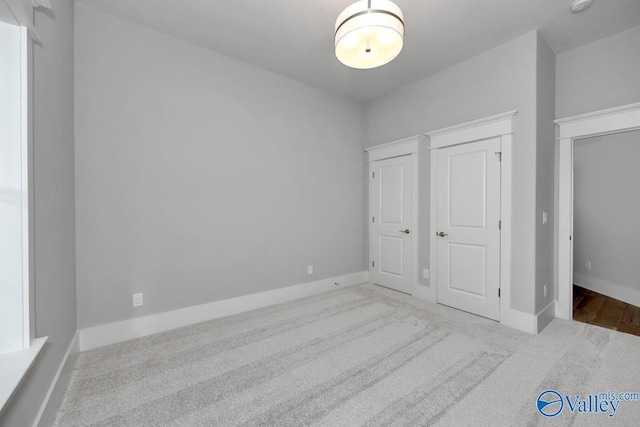 unfurnished bedroom featuring light carpet