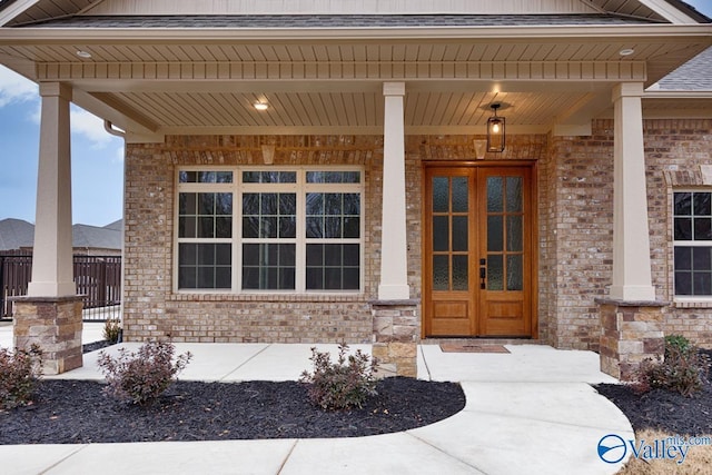 view of exterior entry featuring french doors and covered porch