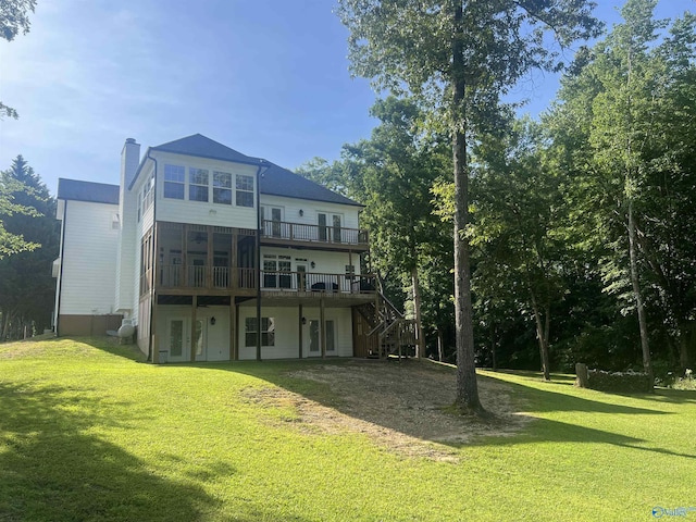 back of house featuring a chimney, stairway, a deck, and a yard