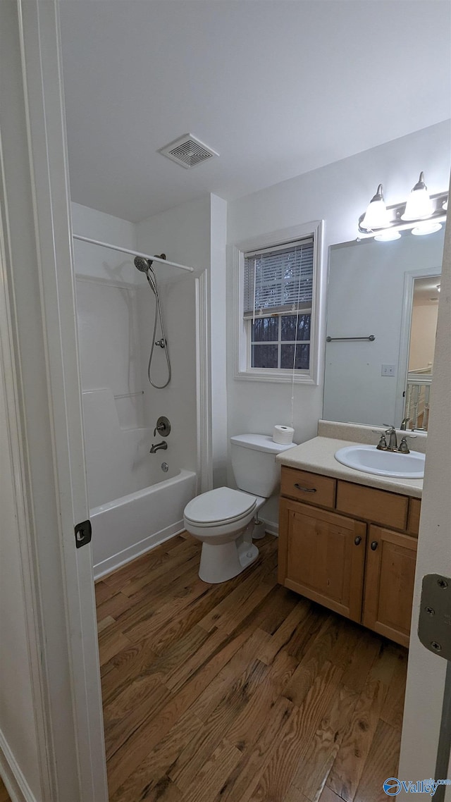 full bathroom with vanity, toilet, hardwood / wood-style floors, and  shower combination