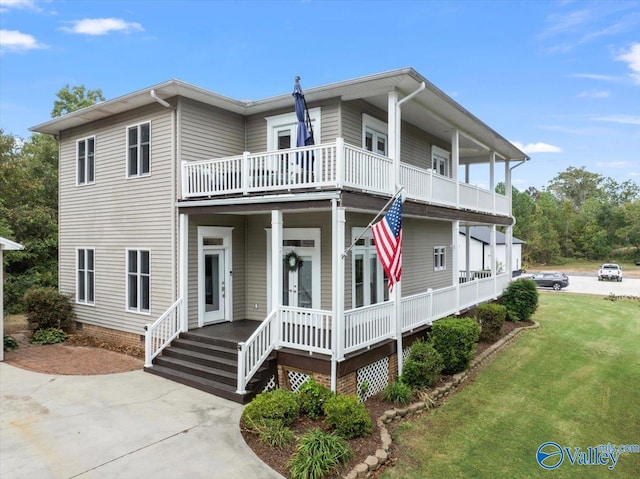 view of front of property with a balcony, a porch, and a front yard