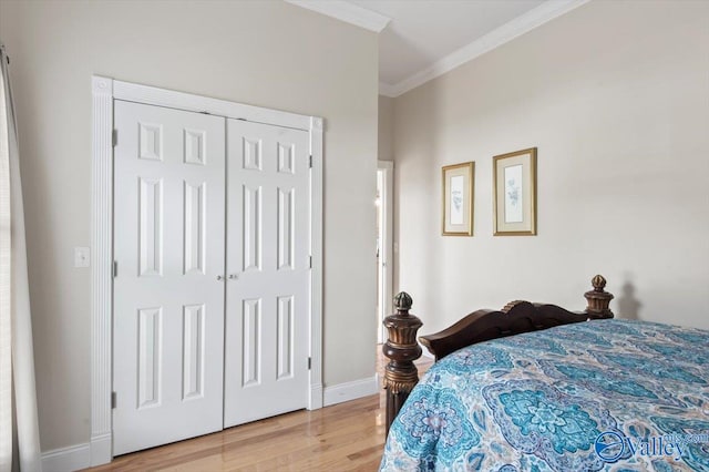 bedroom with light hardwood / wood-style flooring, a closet, and crown molding