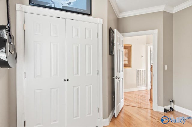 bedroom with crown molding, a closet, and hardwood / wood-style flooring