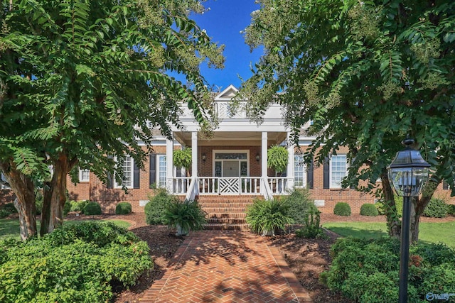 view of front facade featuring crawl space, covered porch, and brick siding