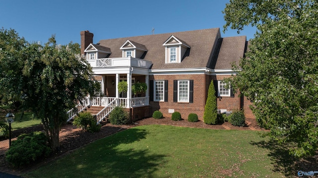 view of front of home featuring brick siding, a porch, a front yard, crawl space, and a balcony