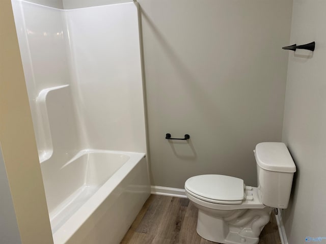 full bath with toilet, wood finished floors, walk in shower, baseboards, and a bathtub