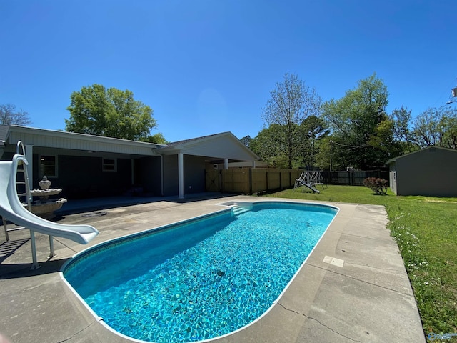 view of pool featuring a fenced in pool, a water slide, a patio area, a fenced backyard, and a lawn