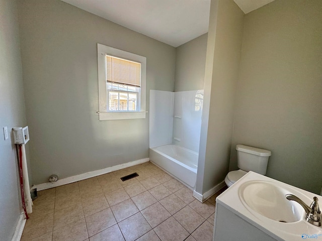 bathroom with toilet, a washtub, vanity, and tile patterned floors