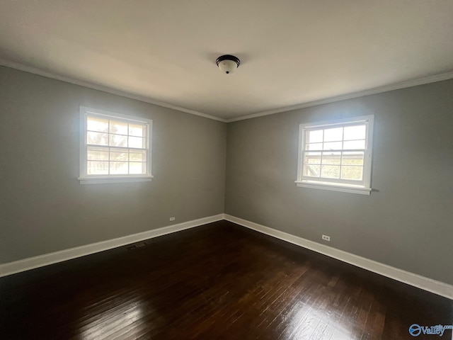 empty room with plenty of natural light, dark hardwood / wood-style floors, and ornamental molding