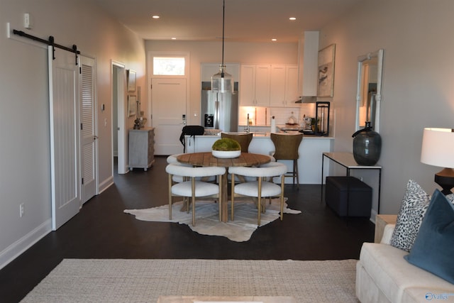 dining space with sink, dark hardwood / wood-style flooring, and a barn door