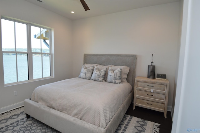 bedroom featuring a water view and ceiling fan