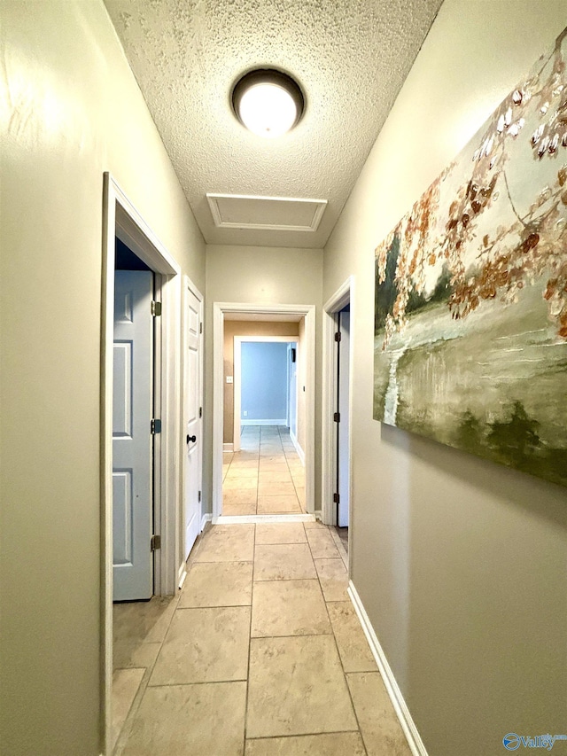753 Walnut St, Gadsden, AL 35901 - hallway with attic access, a textured ceiling, and baseboards