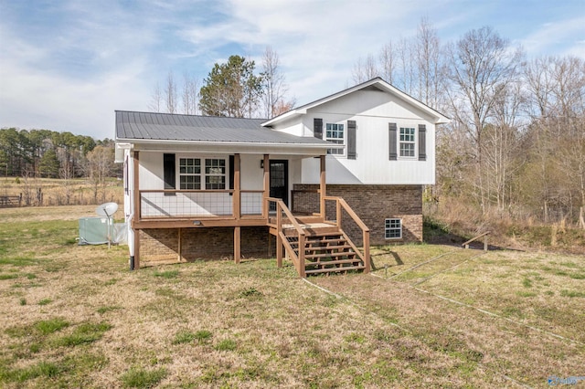 split level home featuring a porch, metal roof, stairs, and a front lawn