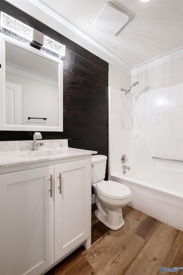 bathroom featuring tub / shower combination, wood finished floors, toilet, and vanity
