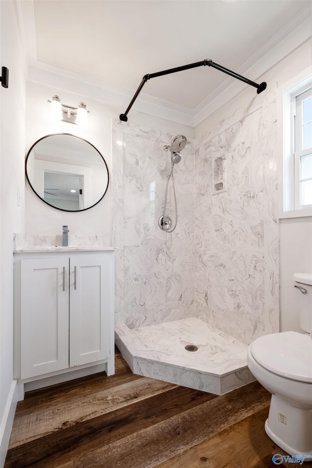 full bathroom featuring toilet, wood finished floors, a shower, and vanity