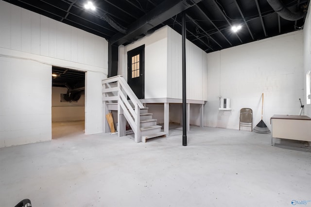 basement featuring stairs and concrete block wall