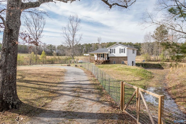 exterior space with driveway, fence, and a front yard