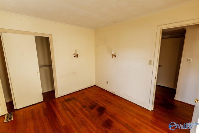 unfurnished bedroom featuring dark hardwood / wood-style flooring and a closet