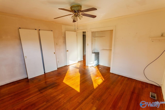 unfurnished bedroom with ceiling fan, dark hardwood / wood-style flooring, and ornamental molding