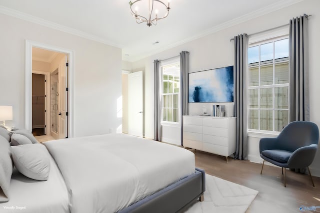 bedroom with an inviting chandelier, crown molding, and light hardwood / wood-style flooring