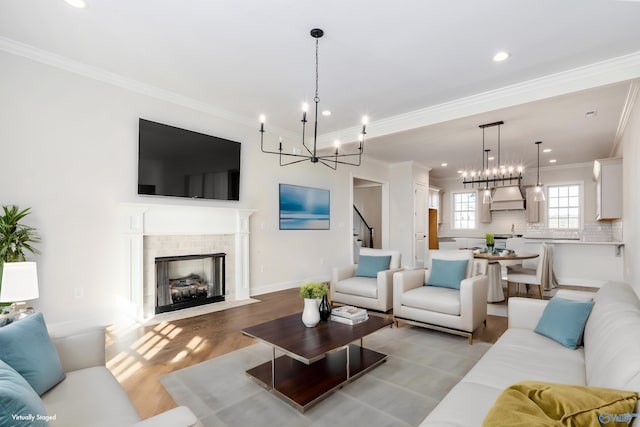 living room with ornamental molding, light wood-type flooring, and a notable chandelier