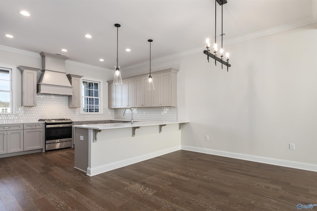 kitchen with gray cabinets, premium range hood, a breakfast bar, pendant lighting, and stainless steel gas range oven