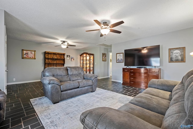 living room with ceiling fan and a textured ceiling