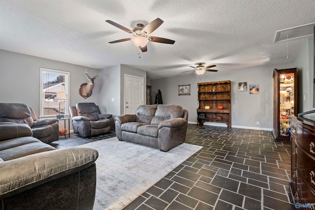 living room with a textured ceiling and ceiling fan