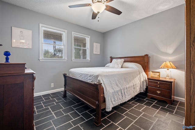 bedroom with a textured ceiling and ceiling fan